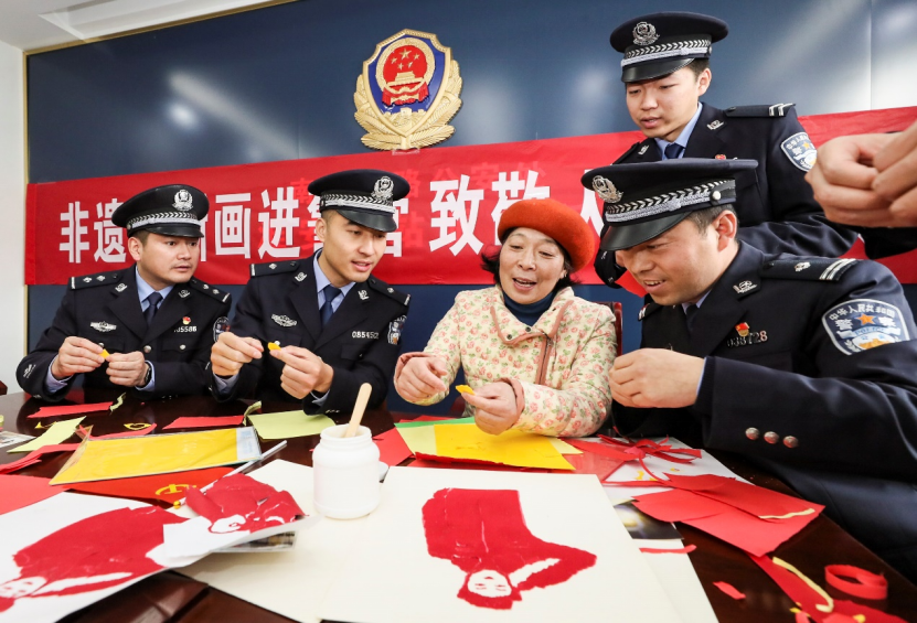 非遗手撕画传人唐玉娟与民警交流手撕画制作技巧(赵启瑞 摄)非遗手撕